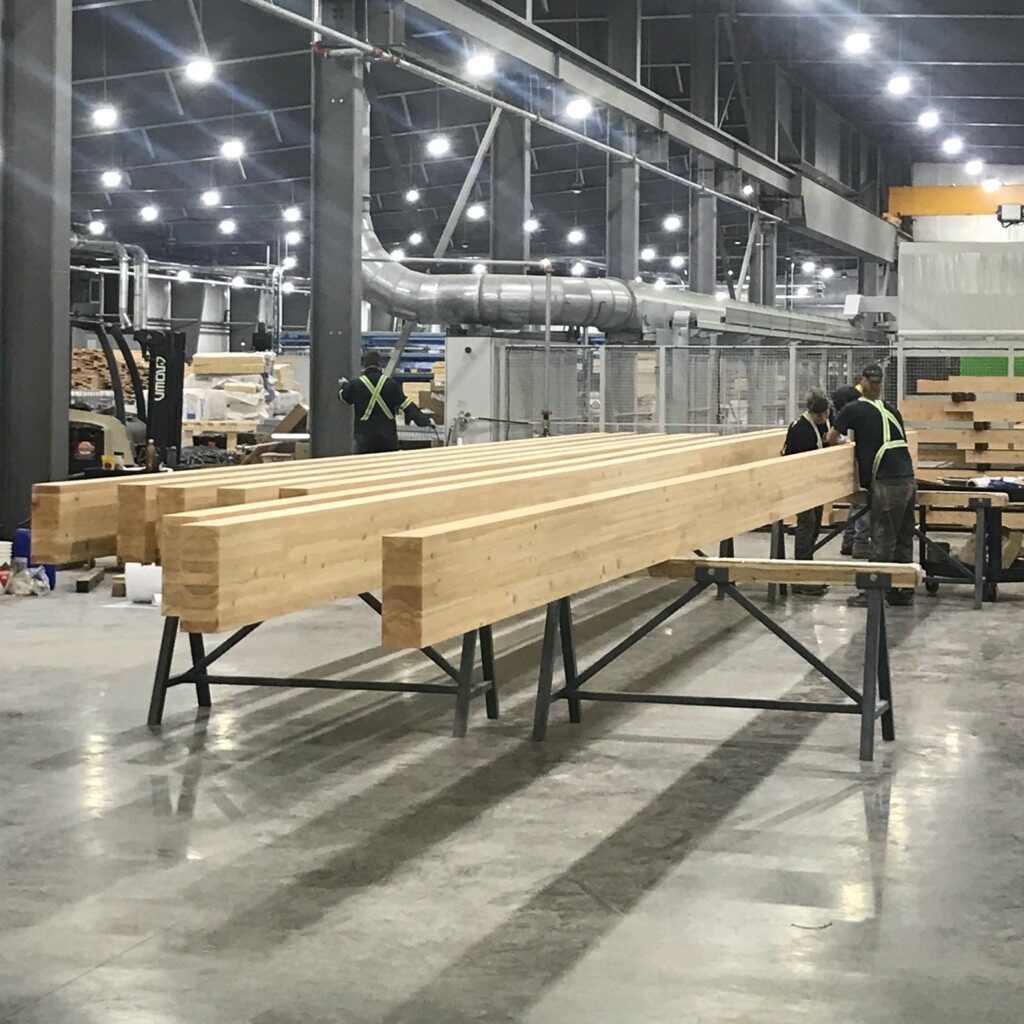 eight mass timber glulam beams being scaled by facility engineers