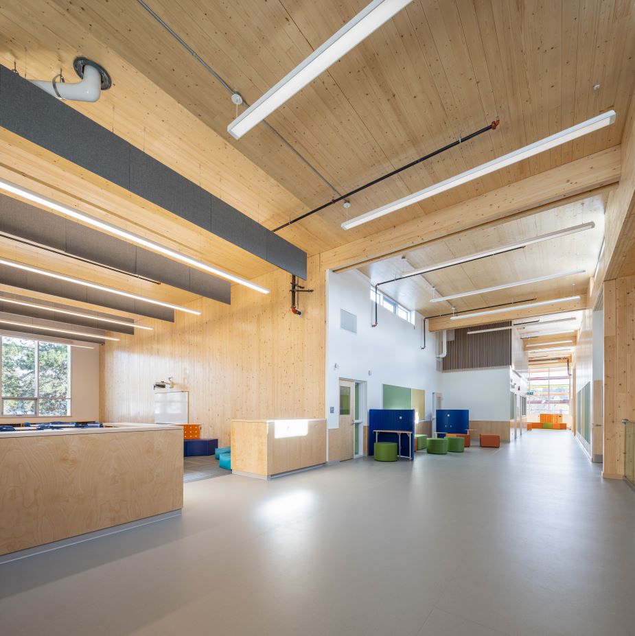 This interior shot of an elementary school shows cross laminated timber walls and ceilings with glulam beams.