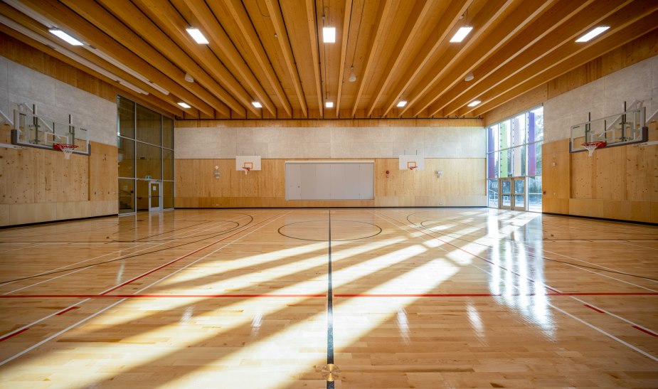 This mass timber gym has glulam beams supporting a cross laminated timber ceiling. It also has cross laminated timber walls and flooring.
