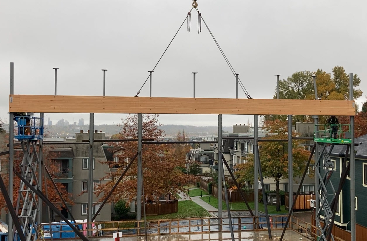 A prefabricated exposed DFL Glulam beam moves into place