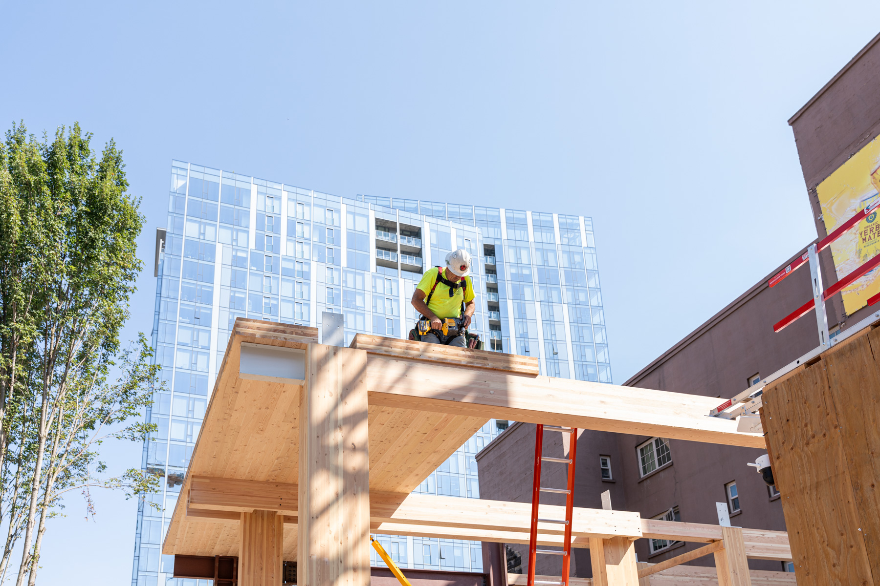 Julia West housing project is a 59,000-square-foot, 12-story apartment building in Portland’s West End. The building is dedicated to affordable senior housing, houses 90 units for Permanent Supportive Housing within a 5,000-square-foot urban site. The project’s setting underscores the viability of mass timber in dense, city environments where efficient construction methods are increasingly being adopted. Julia West housing will be Portland’s tallest mass timber building, featuring exposed cross-laminated timber (CLT) ceilings in every unit and visible timber framing in the public spaces. The selection of mass timber was guided by a Life-Cycle Assessment of various structural systems during the design process, ensuring an environmentally responsible choice. Mass timber’s environmental benefits, including its lower carbon footprint compared to traditional materials like concrete and steel, are central to the building’s design. The mass timber components were prefabricated offsite in Kalesnikoff’s mass timber facility, reducing the need for large staging areas and minimizing on-site- construction time, which is ideal for space-constrained urban areas. The exposed timber frames and glulam columns create a warm, natural environment, aligning with the principles of Trauma-informed design.